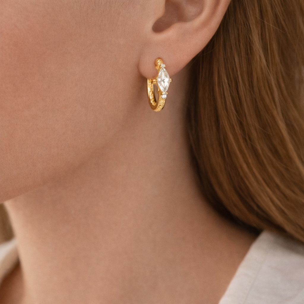 Elegant gold hoop earrings featuring a clear stone accent. Refined, lightweight design made for everyday wear or effortless gifting.