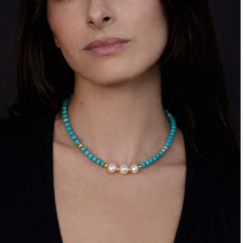 Close-up view of the turquoise and freshwater pearl necklace, showcasing the intricate design with gold spacers between the pearls. The vibrant turquoise and rich pearls are set to complement each other, creating a harmonious and stylish piece.