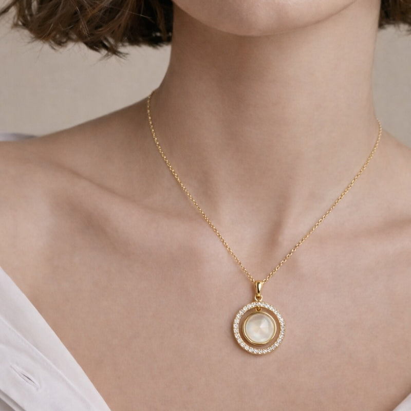 Close-up of the shell pendant necklace, highlighting the intricate zirconia stones encircling the lustrous shell, showcasing the fine craftsmanship and the delicate design of the piece.