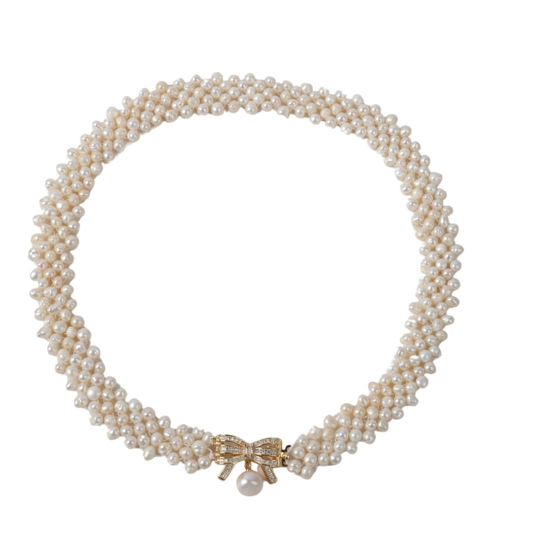 A luxurious handcrafted necklace featuring lustrous freshwater rice pearls and a delicate gold bow pendant with a central pearl. The perfect piece to add elegance and grace to any outfit, whether casual or formal.